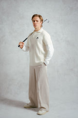 Man holding a golf club against a plain background