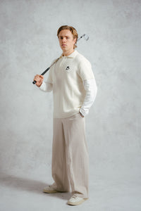 Man holding a golf club against a plain background